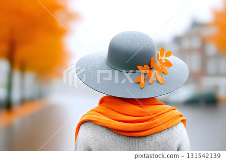 Autumn Fashion: Elegant Grey Hat and Vibrant Orange Scarf in Seasonal Street Scene Generative AI 131542139