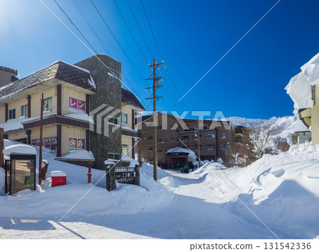 Winter streetscape of Shiga Kogen Hotaru Onsen lined with ski rental shops and hotels (Yamanouchi Town, Nagano Prefecture) 131542336