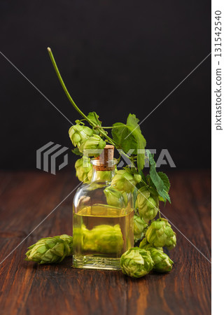 Hop Extract in Glass Bottle with Fresh Hops on Wooden Surface Hop Extract in Glass Bottle with Fresh Hops on Wooden Surface 131542540