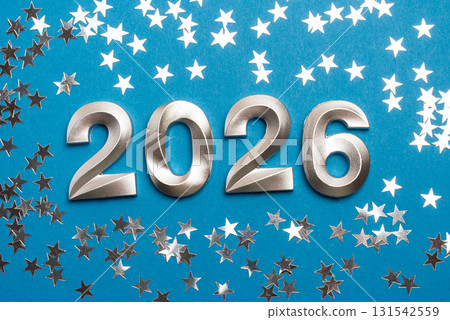 Metallic 2026 Numbers with Silver Star Confetti on Blue Background Metallic 2026 Numbers with Silver Star Confetti on Blue Background 131542559