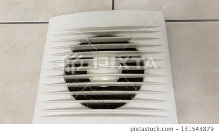 Close-up of an electric range hood clogged with dust and cobwebs, dirty exhaust fan in the bathroom with accumulated dirt, concept of pollution, poor ventilation and need of cleaning 131543879