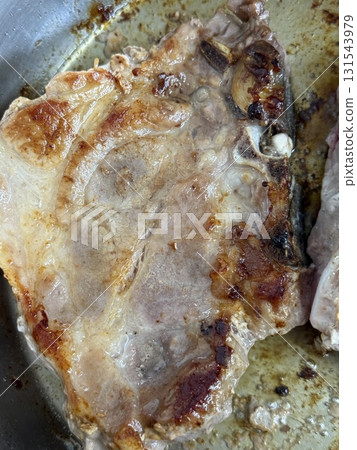 Closeup of a grilled pork chop. Pan-fried pork chops in frying pan. 131543979
