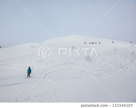 滑雪者從新雪覆蓋的斜坡上滑下,人們徒步登上山頂(長野縣白馬五龍) 滑雪者從新雪覆蓋的斜坡上滑下,人們徒步登上山頂(長野縣白馬五龍) 131544107