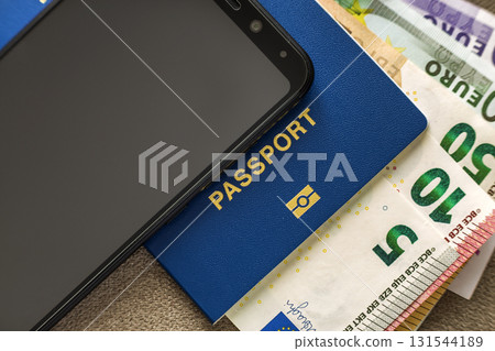 Modern black cellphone, Euro money banknotes bills and travel passport on copy space background. Travelling light, comfortable journey concept. 131544189
