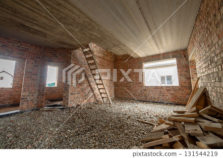 Interior of unfinished brick house with concrete floor and bare walls ready for plastering under construction. Real estate development 131544219
