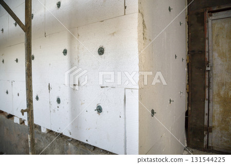 Insulation work of house walls with styrofoam sheets. Insulation work of house walls with styrofoam sheets. 131544225