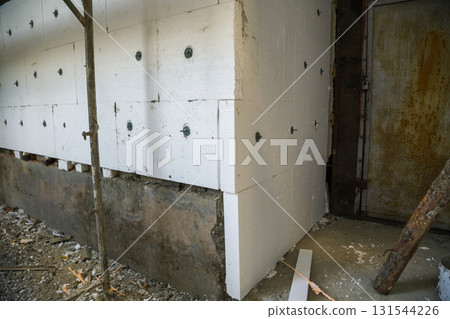 Insulation work of house walls with styrofoam sheets. Insulation work of house walls with styrofoam sheets. 131544226