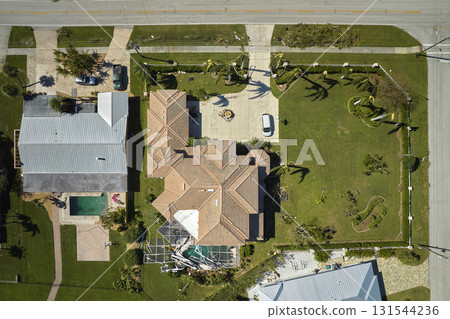 Hurricane Ian destroyed swimming pool lanai enclosure on house yard in Florida residential area. Natural disaster and its consequences 131544236