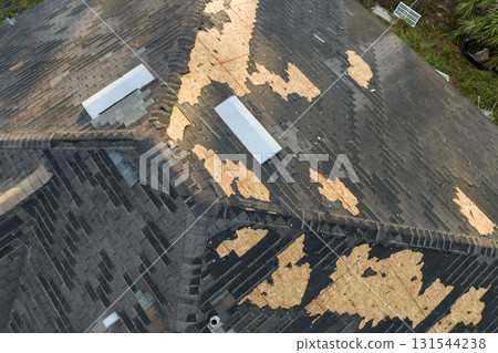 Hurricane Ian destroyed house roof in Florida residential area. Natural disaster and its consequences 131544238
