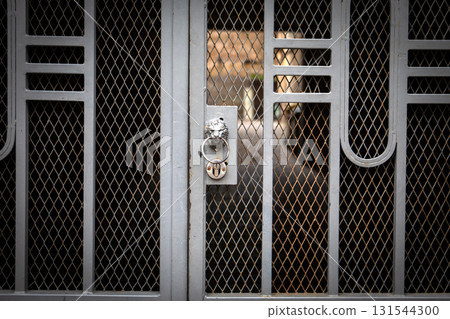Close-Up of Locked Metal Gate with Decorative Pattern and Rust 131544300