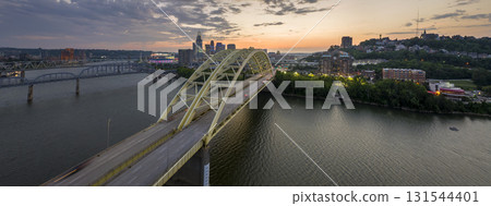 Highway traffic in Cincinnati, Ohio on Daniel Carter Beard Bridge with brightly illuminated high skyscraper buildings in downtown district. American city with business financial district at night Highway traffic in Cincinnati, Ohio on Daniel Carter Beard Bridge with brightly illuminated high skyscraper buildings in downtown district. American city with business financial district at night 131544401