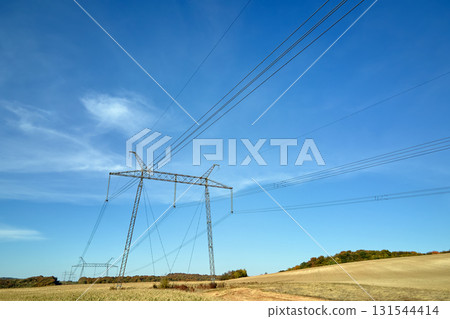 High voltage tower with electric power lines transfening electrical energy through cable wires 131544414