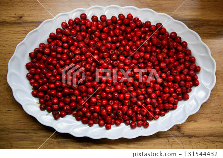 Crataegus or hawthorn berries in ceramic bowl on rustic wooden background. 131544432