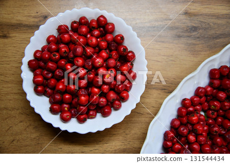 Crataegus or hawthorn berries in ceramic bowl on rustic wooden background. 131544434