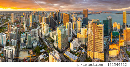Downtown district of Miami in Florida, USA. Urban landscape of high skyscraper buildings in modern American city at sunset Downtown district of Miami in Florida, USA. Urban landscape of high skyscraper buildings in modern American city at sunset 131544512