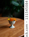 Marigolds in a small antique ceramic vessel 131545084