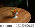 Marigolds in a small antique ceramic vessel 131545085