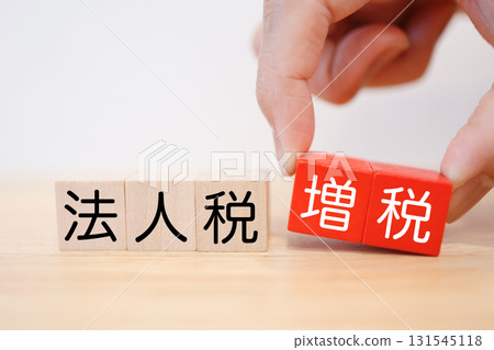 Wooden blocks representing a corporate tax increase. White background. Copy space available. 131545118