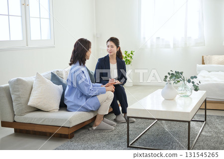 A young businesswoman explaining to a middle-aged woman A young businesswoman explaining to a middle-aged woman 131545265
