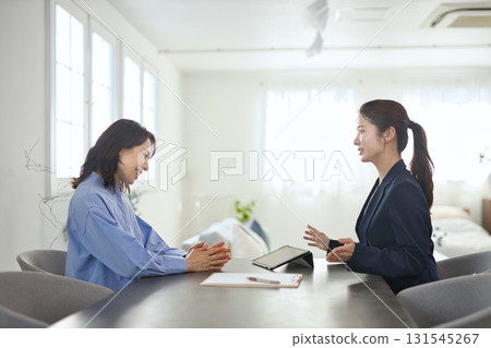 A young businesswoman explaining to a middle-aged woman A young businesswoman explaining to a middle-aged woman 131545267
