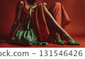 Stylish model poses gracefully with a trendy green handbag, matching shoes, and sunglasses, creating a vibrant contrast against a bold red backdrop, showcasing a fashion forward look 131546426