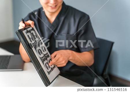 一名男醫生在醫院檢查期間一邊展示 X 光片一邊解釋 131546516