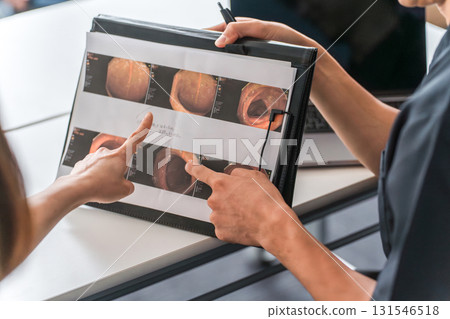 A female patient and a male doctor, nurse, and counselor having a medical examination, consultation, and counseling at a hospital 131546518