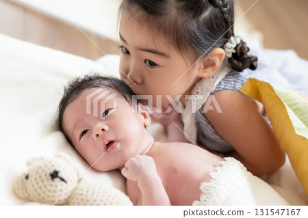 Family Newborn Older sister kissing younger brother 131547167