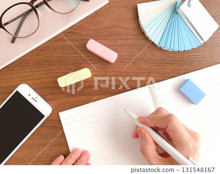 Hands of a woman studying at a wooden table 131548167