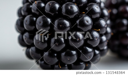 Detailed macro view of a fresh, dark blackberry highlighting its natural texture 131548364