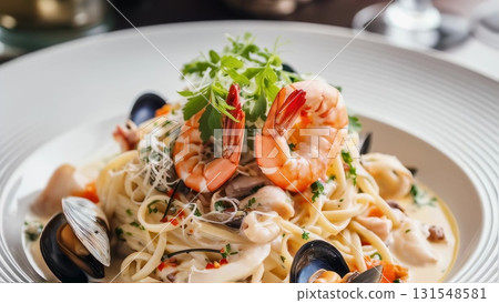 Creamy linguine adorned with succulent shrimp, mussels, clams, and fresh parsley garnishing white ceramic plate, highlighting gourmet seafood pasta 131548581