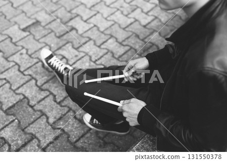Street drummer sitting with drumsticks 131550378