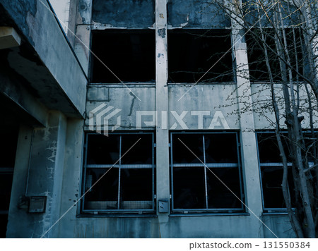 A dark abandoned school building with broken windows 131550384