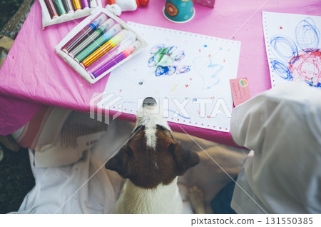 Dog watching children draw with markers 131550385