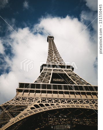 Eiffel Tower closeup against blue sky with clouds 131550445