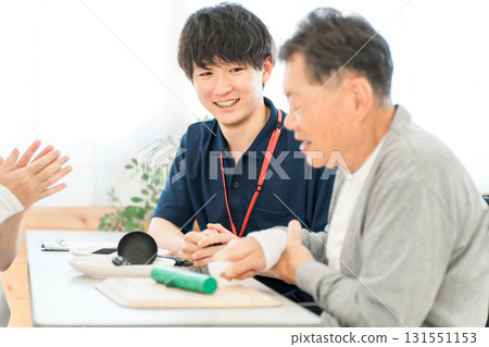 Occupational therapist rehabilitating a senior man, male care manager staff 131551153