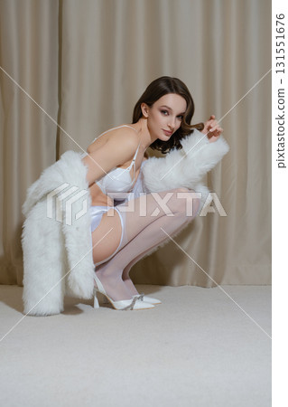 Woman in lingerie poses elegantly in hotel boudoir setting 131551676