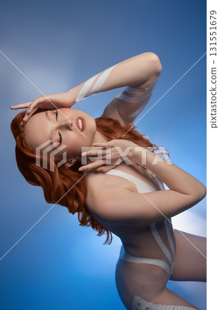 Beauty woman showcasing body art with tape and fur in studio setting Beauty woman showcasing body art with tape and fur in studio setting 131551679