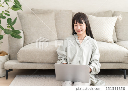 一位女士在客廳的沙發上使用電腦（視訊、副業、SNS、在家工作） 131551858