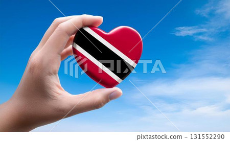 Heart-shaped Trinidad and Tobago flag held by hand against blue sky 131552290