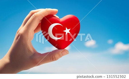 Heart-shaped Turkish flag held by hand against blue sky 131552302