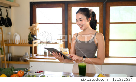 Young woman using tablet with recipe online in the kitchen 131552554