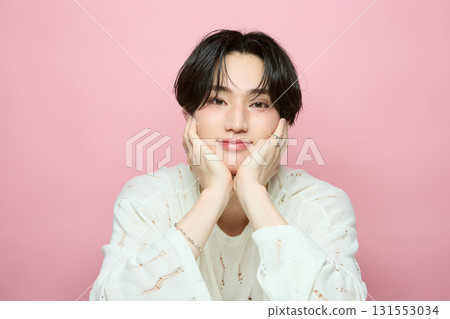 粉紅色背景中一位可愛的亞洲年輕男子的肖像 131553034