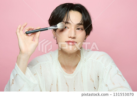 粉紅色背景中一位可愛的亞洲年輕男子的肖像 131553070