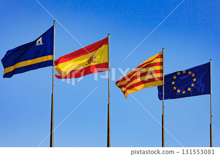 Flags of Spain, Salou, Catalonia, European Union against blue sky 131553081