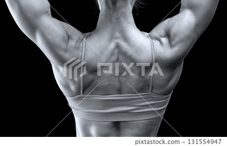Strong woman with muscular body posing against black background Strong woman with muscular body posing against black background 131554947