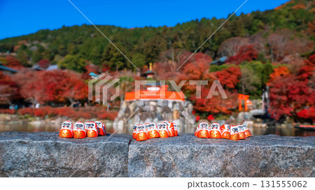 Daruma dolls by pond with autumn garden of Katsuoji temple, Minoh 131555062