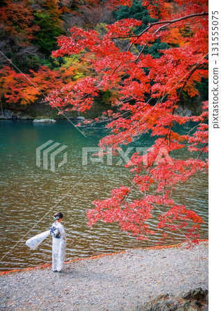 Japanese woman in kimono at Arashiyama river by red maple leaf 131555075