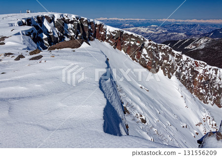 The crater wall of Mount Iodake in the Yatsugatake mountain range and the mountain range of the Northern Alps in winter 131556209