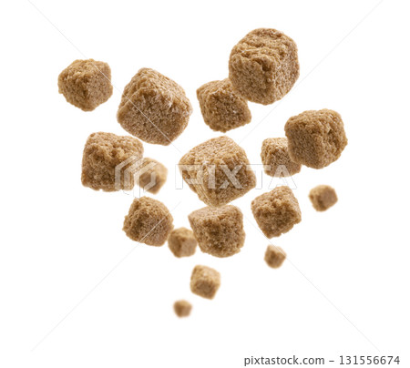 Brown cane sugar levitates on a white background Brown cane sugar levitates on a white background 131556674